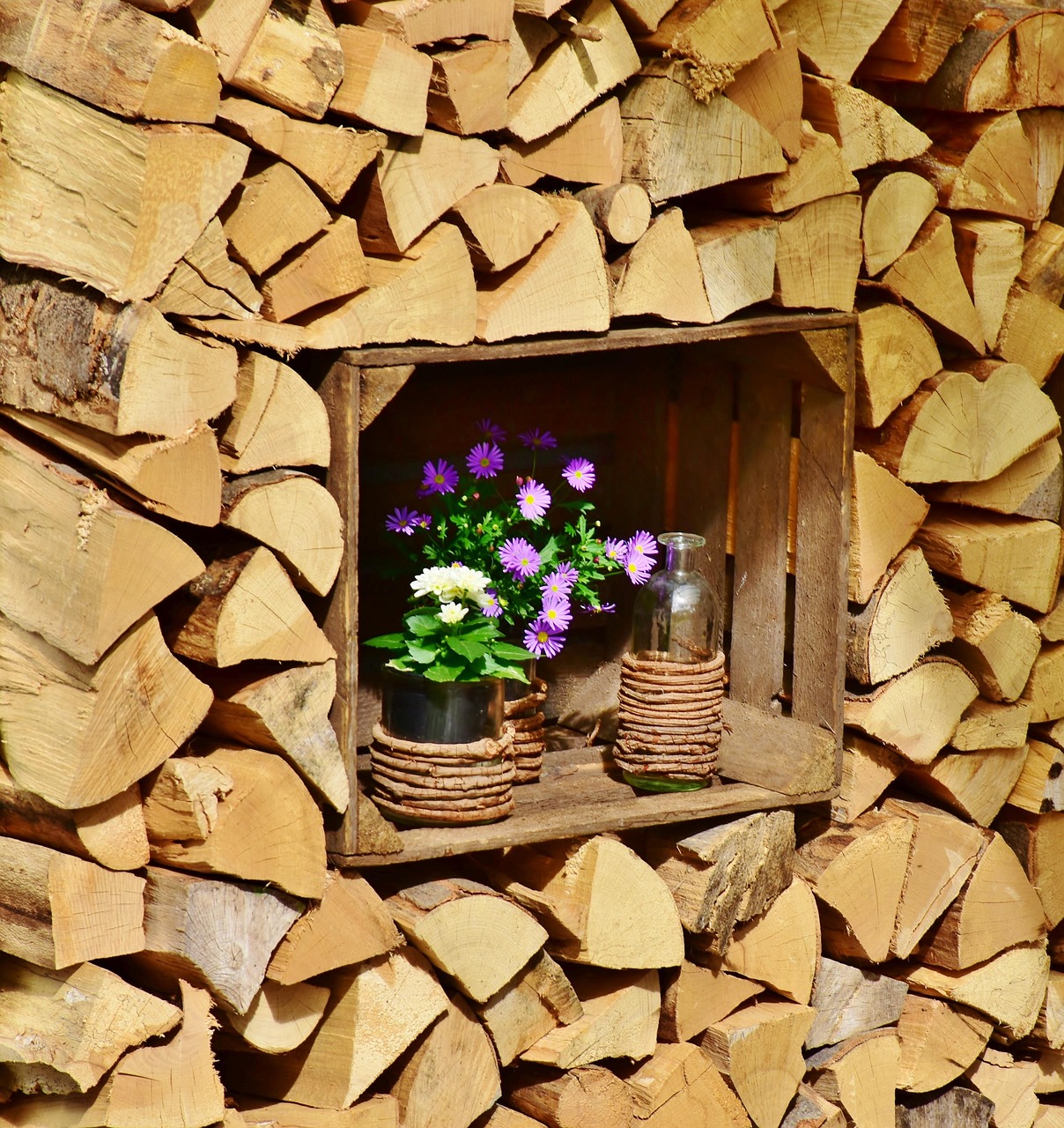 Holzstapel mit dekorativer Holzkiste und Blumen als Symbol für nachhaltige Entwicklung und ESG-Reporting